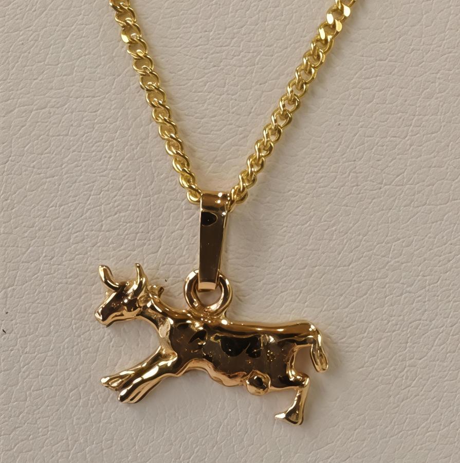 Kultainen maskottiriipus iloinen lehmä